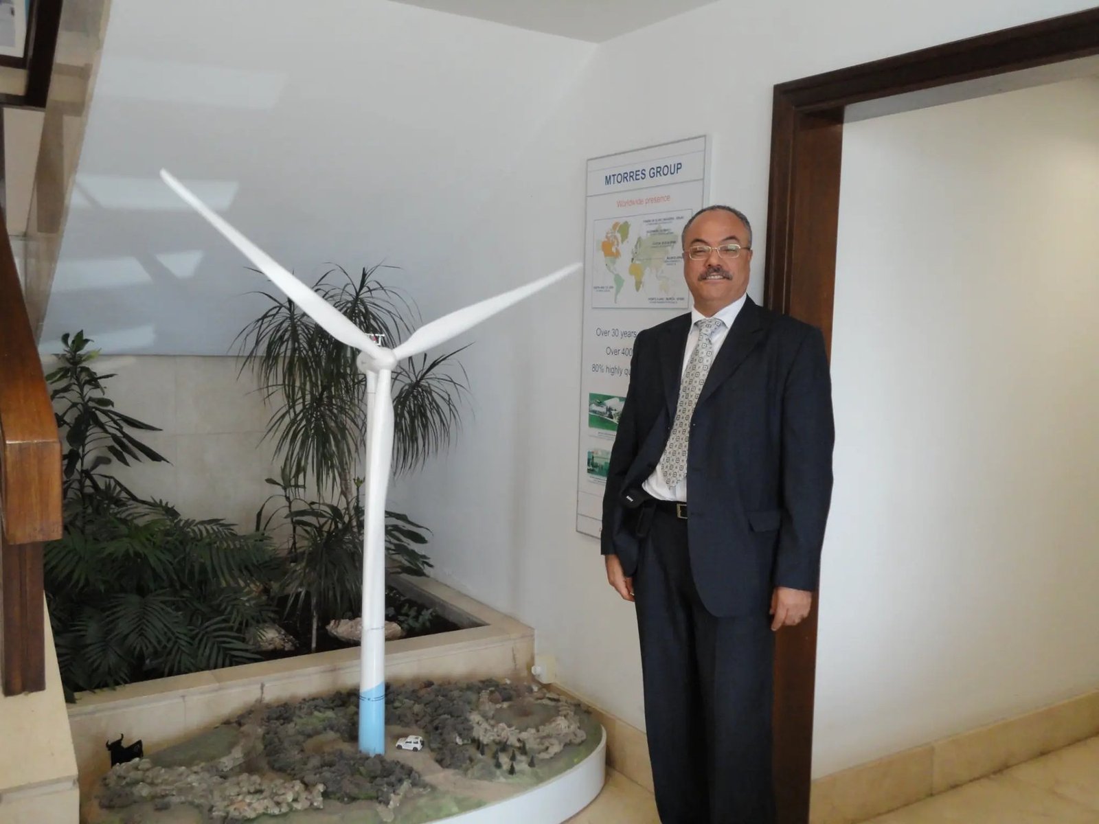 Adel Gastli beside a wind-energy technology exhibit during a Spain renewable-energy visit